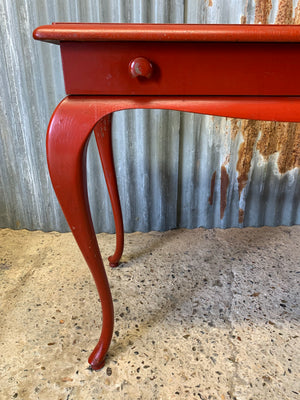 A red cabriole leg table
