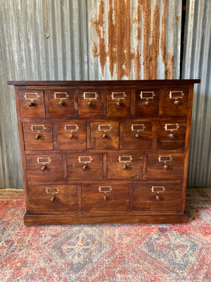 A large bank of graduated apothecary drawers