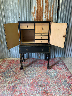 An ebonised Chinoiserie fitted cabinet on stand