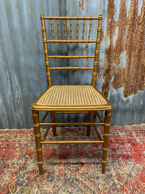 A set of four faux bamboo chairs with cane seats