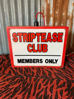 A striptease club illuminated light box advertising sign