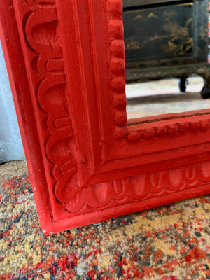 A large red floor standing mirror