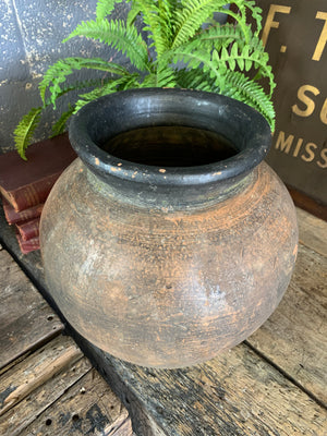A large terracotta urn with black rim
