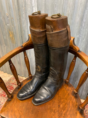 A pair of black leather riding boots with wooden lasts
