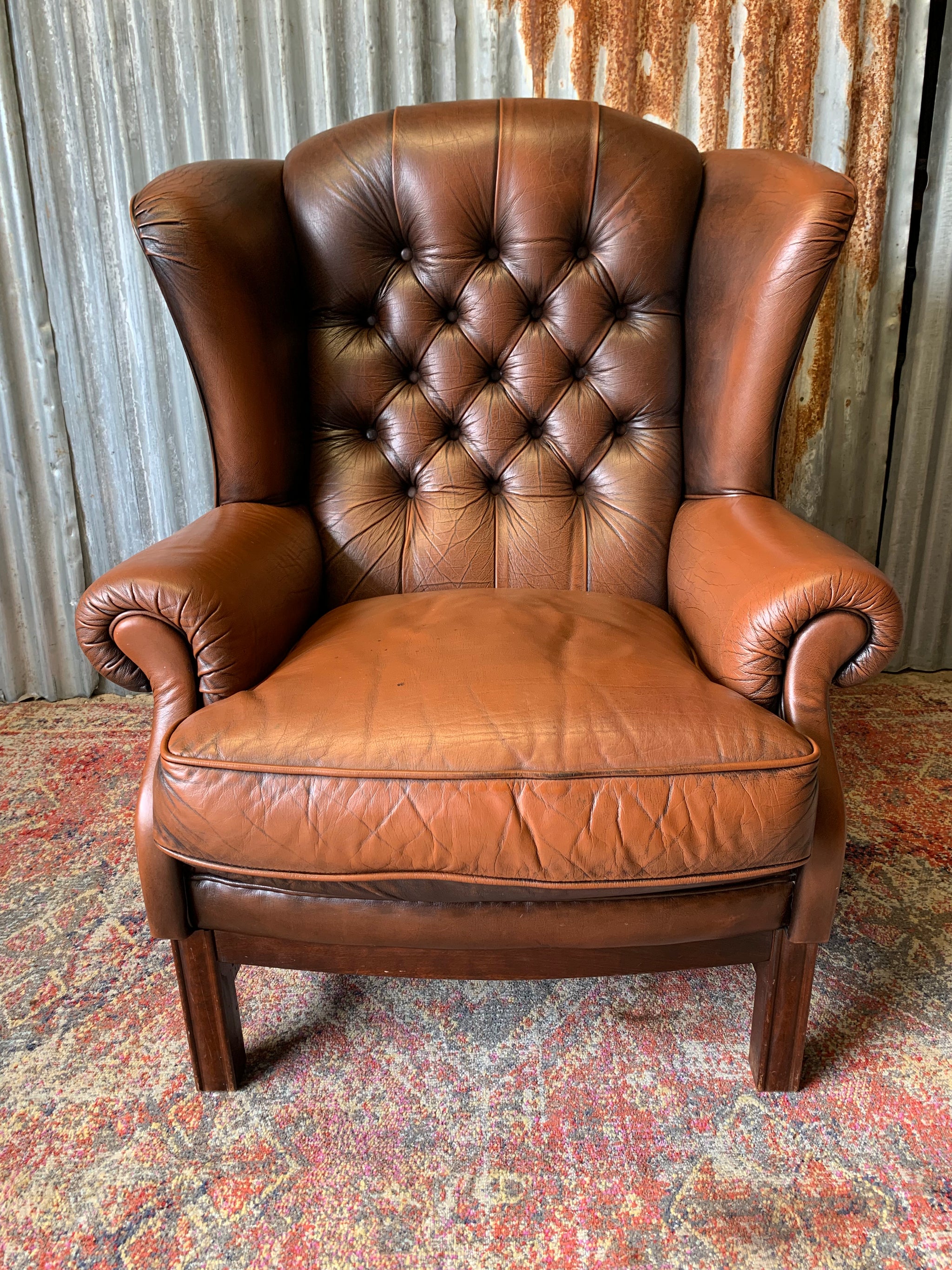 A brown wingback Chesterfield armchair with button back Belle