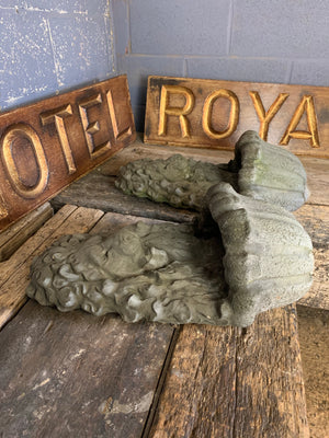 A pair of cast stone lion head wall planters