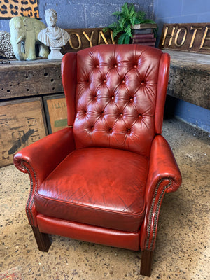 A red wingback Chesterfield recliner armchair