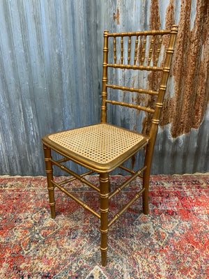 A set of four faux bamboo chairs with cane seats