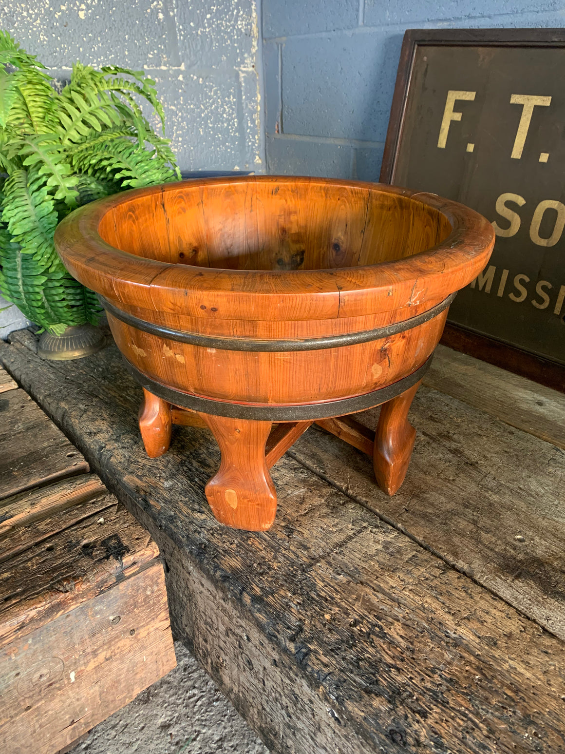 A Chinese iron bound wooden bowl on legs