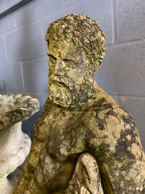 A weathered statue of Hercules