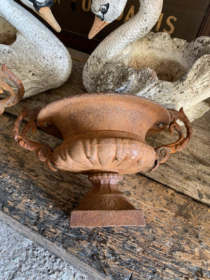 A pair of cast iron urns with handles