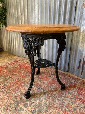 A cast iron Britannia garden table with oak top