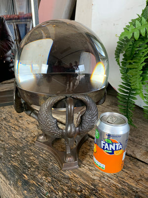 A large fortune teller's crystal ball on a bronze stand