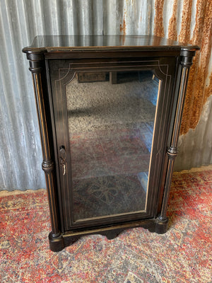 An ebonised display cabinet with glass door