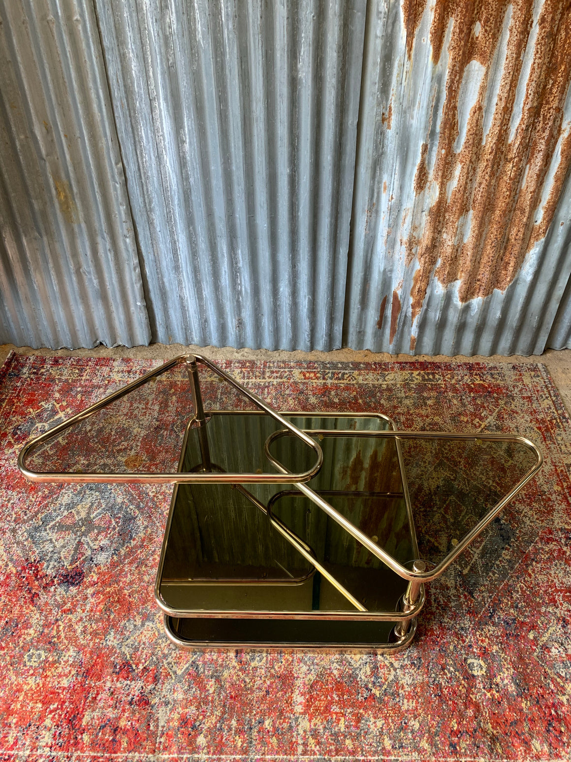 A Milo Baughman style swivel brass and mirrored glass table