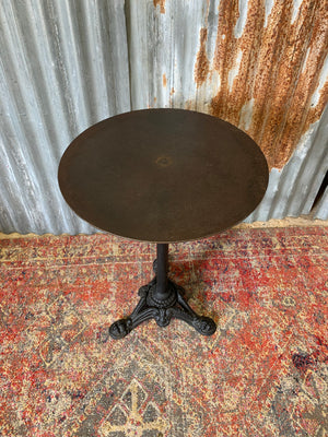 A black cast iron circular bistro table
