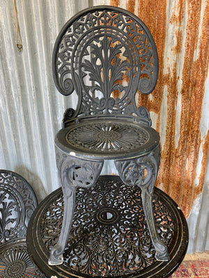 A black cast metal garden table and two chairs