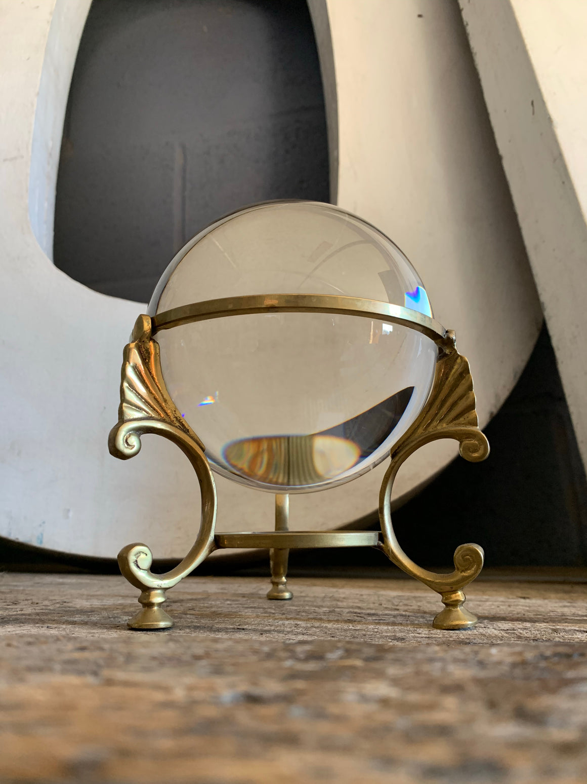 A large fortune teller's crystal ball on a brass tripod base