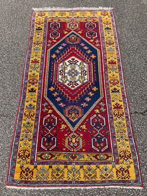A rectangular Persian rug- red ground with yellow accents