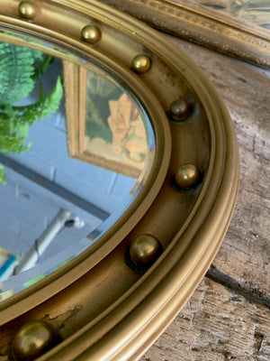 A large 19th century Regency-style oval mirror