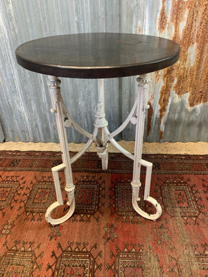 A white cast iron bistro garden table with wooden top