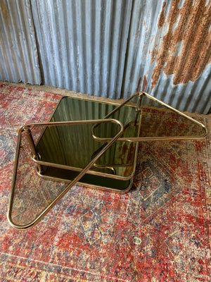 A Milo Baughman style swivel brass and mirrored glass table