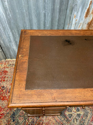 A small wooden pedestal desk