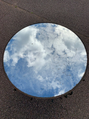 A circular wrought iron table with mirrored top
