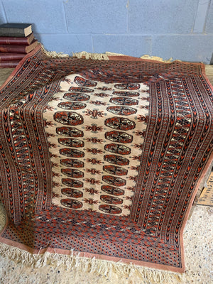 A rectangular beige and orange ground Persian Bokhara rug