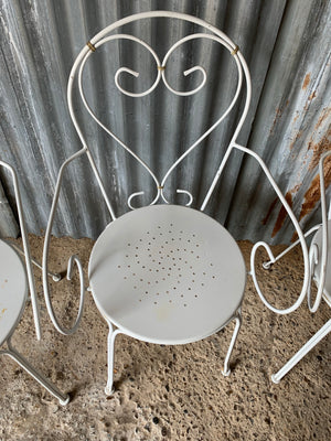 A set of four French white wire work garden chairs