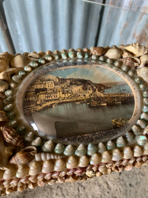 A large seashell encrusted trinket box with domed harbour scene