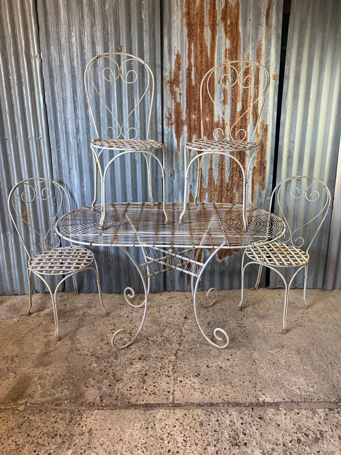 A white French wirework garden table and four chairs