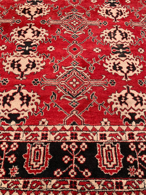 A very large hand woven Persian red ground rug - over 12ft