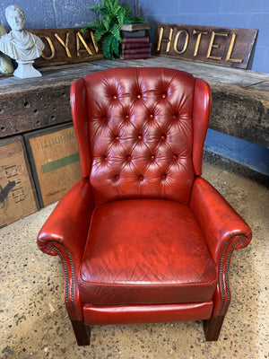 A red wingback Chesterfield recliner armchair
