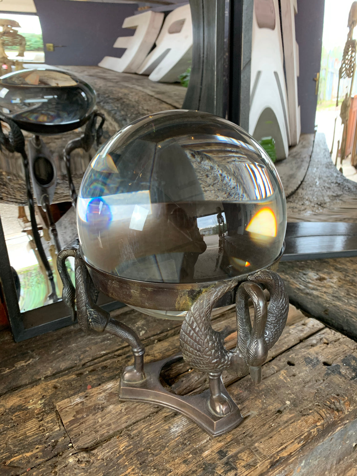 A large fortune teller's crystal ball on a bronze stand