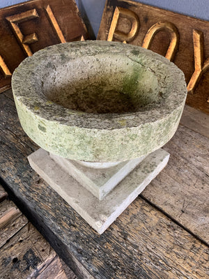 A cast stone font bird bath