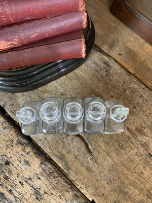 A collection of five squared apothecary bottles