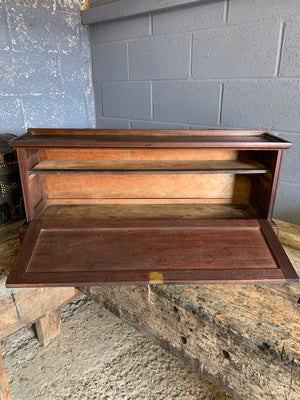 A mahogany locking drop front cabinet with internal shelf