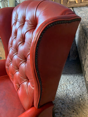 A red wingback Chesterfield recliner armchair