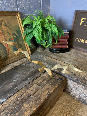 A trio of gilded bronze flocks of birds in flight