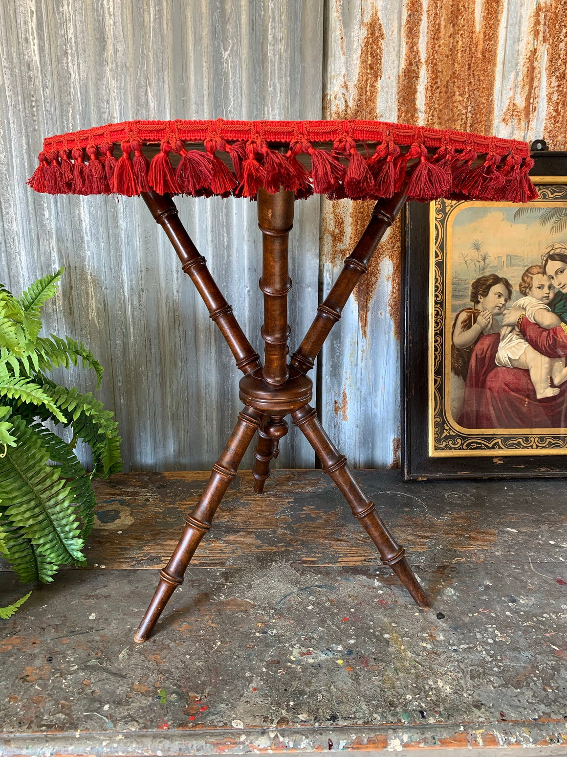 An octagonal red velvet faux bamboo gypsy table