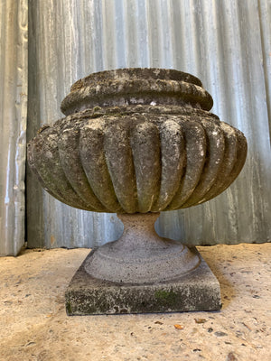 A pair of large gadrooned cast stone urns