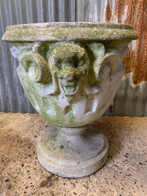 A very large urn with jester head detailing
