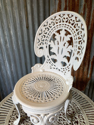 A white cast metal garden set - a large table and two chairs