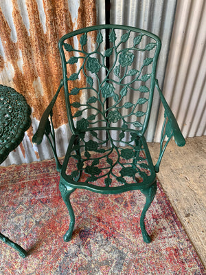 A green Victorian style table and two chairs set