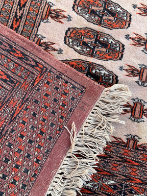 A rectangular beige and orange ground Persian Bokhara rug