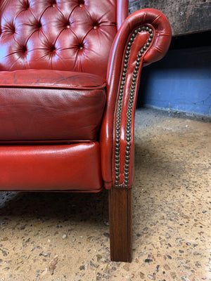 A red wingback Chesterfield recliner armchair