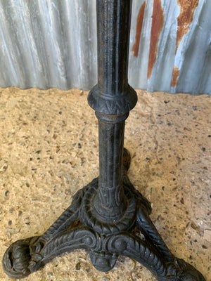 A black cast iron bistro garden table with white marble top