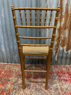 A set of four faux bamboo chairs with cane seats