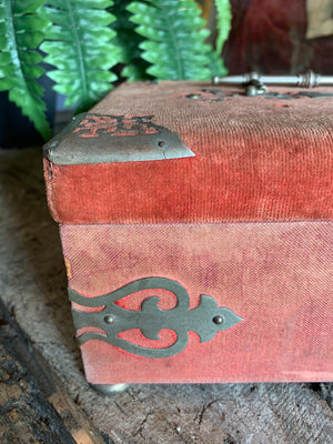 An ornate red velvet sewing box